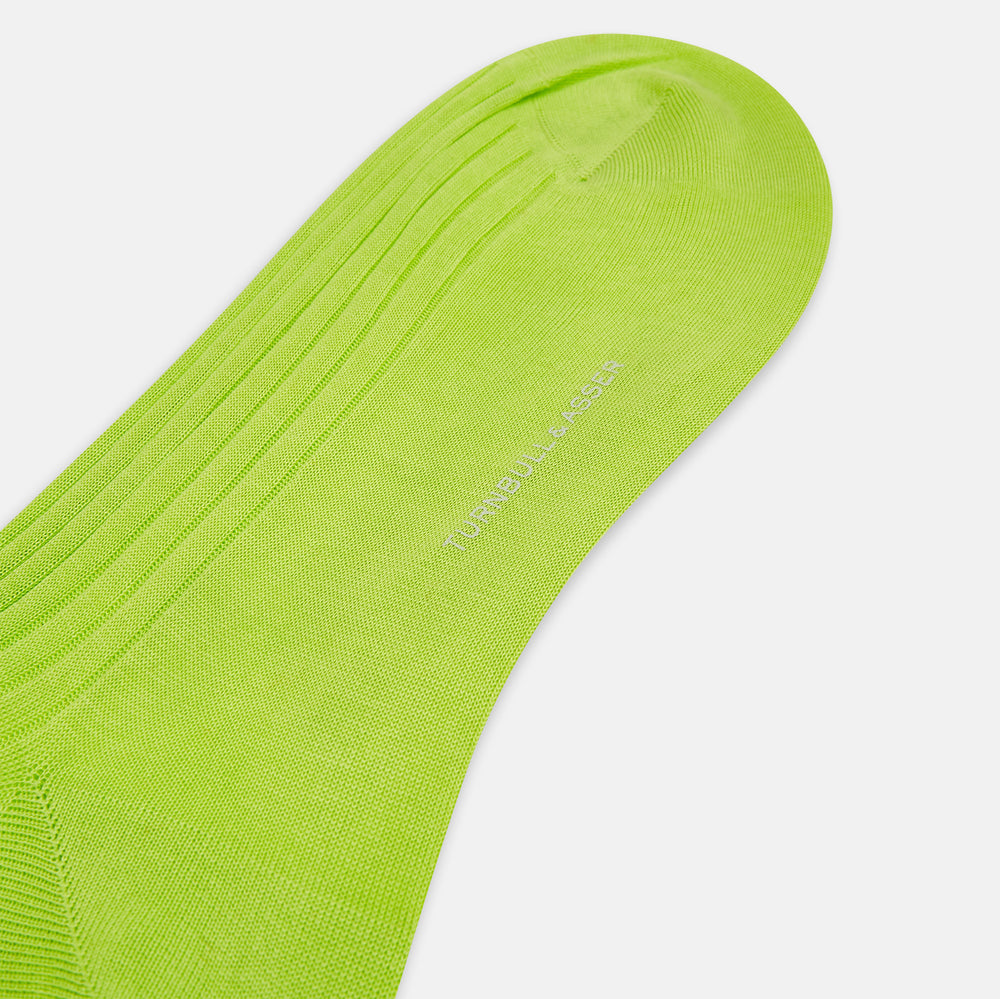The Turnbull & Asser Lime Long Sock is a single bright green, knee-high sock with a ribbed texture, crafted from soft mercerised cotton, shown against a white background.