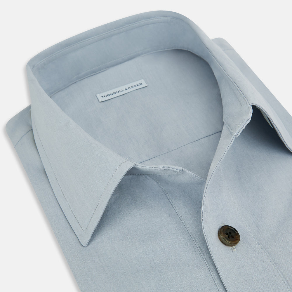 The Turnbull & Asser Grey Hyde Overshirt is a long-sleeve button-up made from sanforised cotton, featuring a single chest pocket and dark buttons, shown against a plain white background.