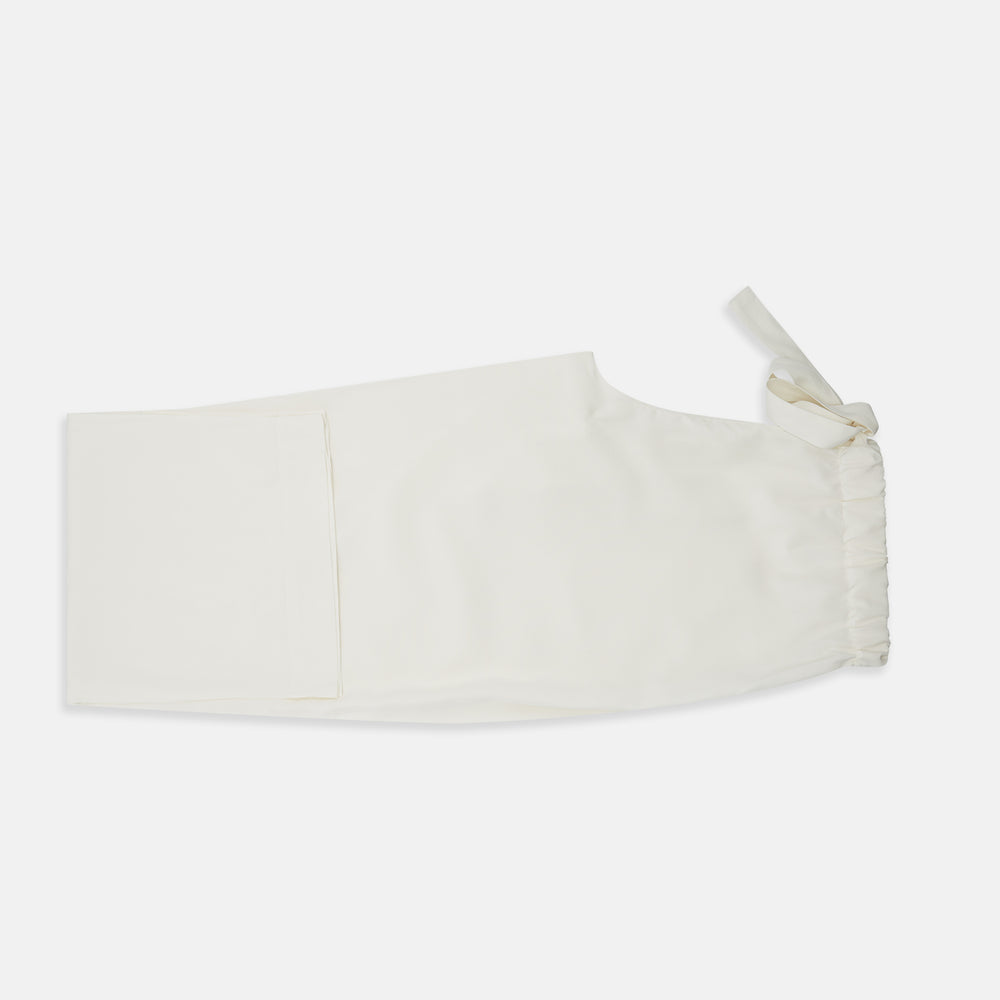 The Women's Harriet Cream Silk Pyjama Set by Turnbull & Asser features a white sand-washed silk button-up top with black piping and chest pocket, plus matching drawstring pants, all shown against a white background.
