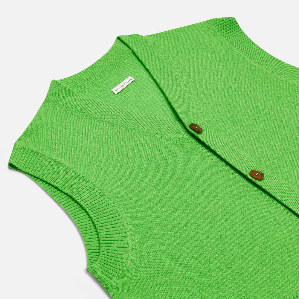 The Turnbull & Asser Lime Green Fine Merino V-Neck Sleeveless Cardigan features dark buttons, two front pockets, and a sophisticated look, all set against a plain white background.