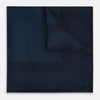 View 1 of product The Turnbull & Asser Navy and Blue Dot Silk Pocket Square features a handmade design in navy silk with small light blue dots and a crisp border, finished with one corner folded to display the reverse side.