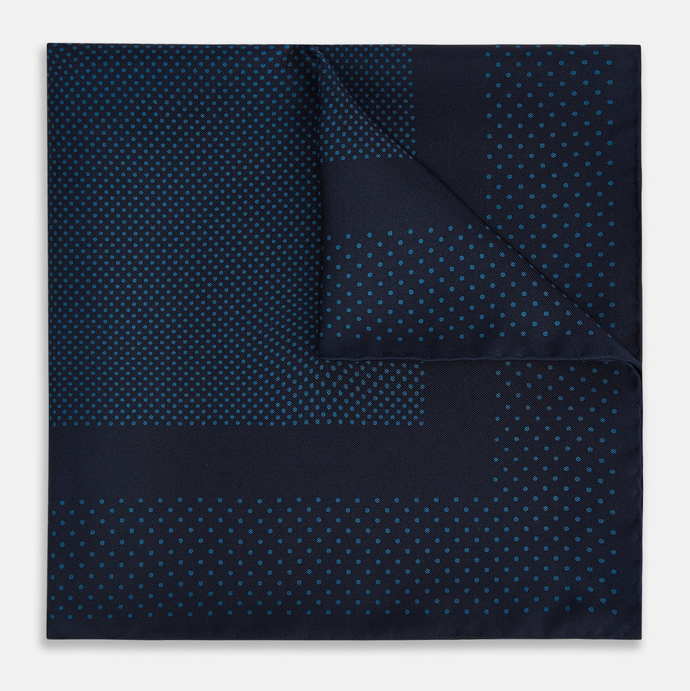 The Turnbull & Asser Navy and Blue Dot Silk Pocket Square features a handmade design in navy silk with small light blue dots and a crisp border, finished with one corner folded to display the reverse side.