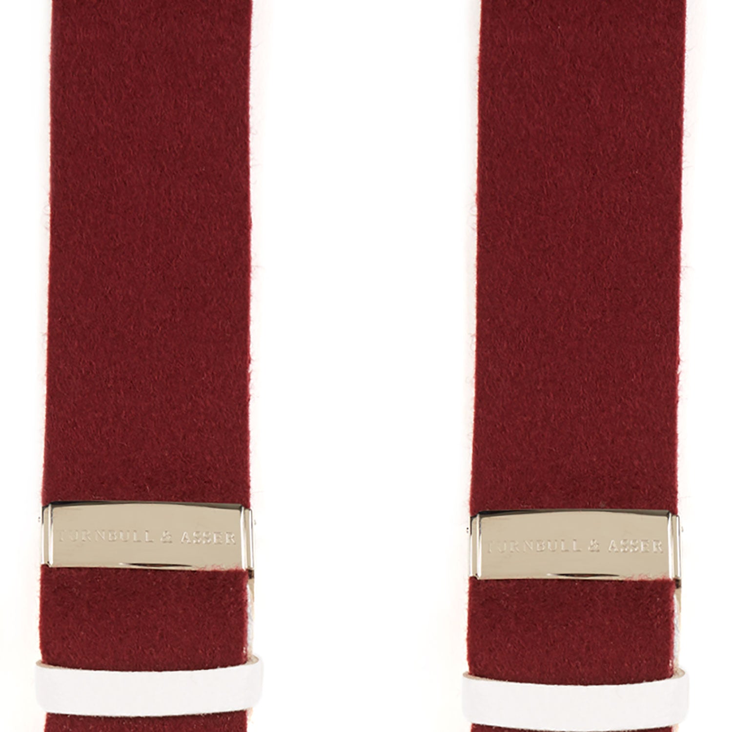 View 2 of product A pair of Turnbull & Asser Bordeaux Adjustable Felt Braces, featuring white leather ends and gold metal adjusters, made in England, are displayed vertically on a plain white background.