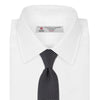 View 2 of product The Turnbull & Asser Black and White Spot Printed Silk Tie, shown neatly rolled on a plain white background, is an essential accessory to elevate any smart attire.