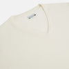 View 2 of product The Turnbull & Asser Ivory Cashmere V-neck Jumper features long sleeves with ribbed cuffs and hem, showcasing timeless knitwear style against a white background.