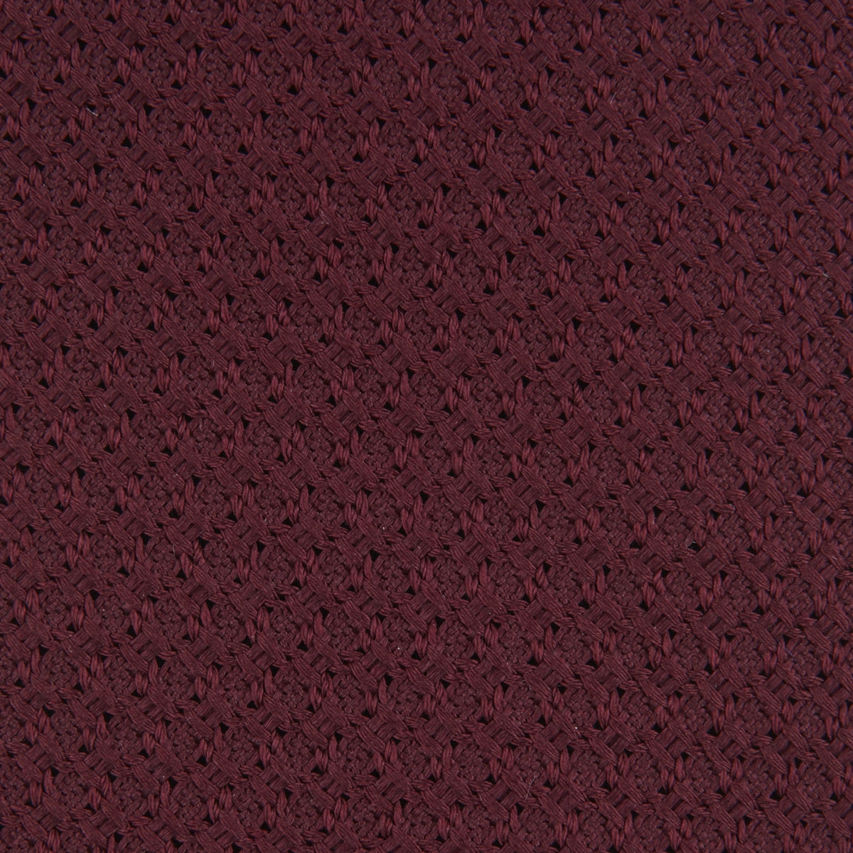 View 3 of product The Turnbull & Asser 7 fold Grenadine Silk Plain Tie is shown rolled on a white background, highlighting its textured maroon design as a versatile addition to any wardrobe.