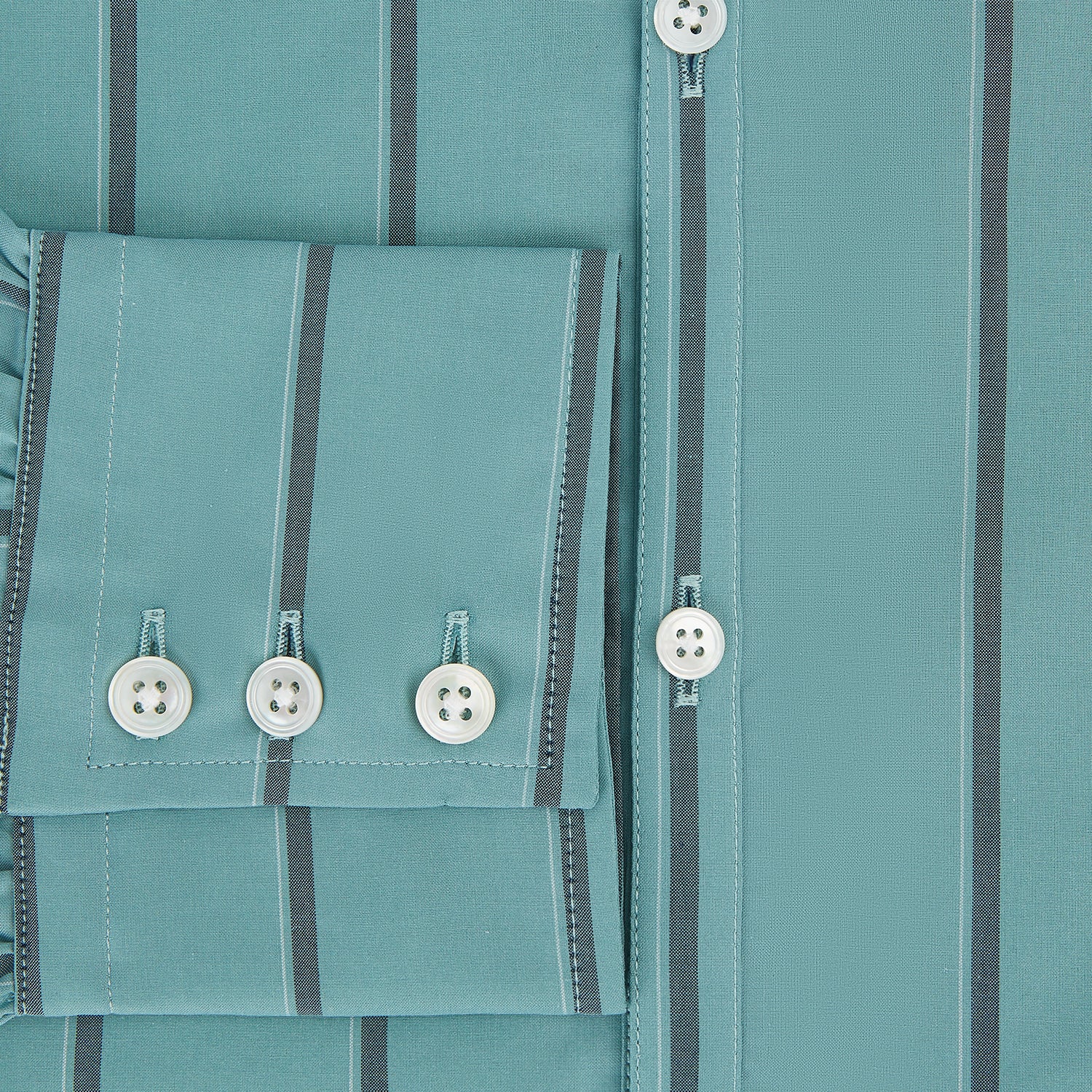 Image 4 of product The Turnbull & Asser Sage Track Stripe Westminster Shirt features long sleeves, a tailored fit, a collar, and vertical dark blue stripes, with button closures down the front and at the cuffs, shown laid flat on a white background.