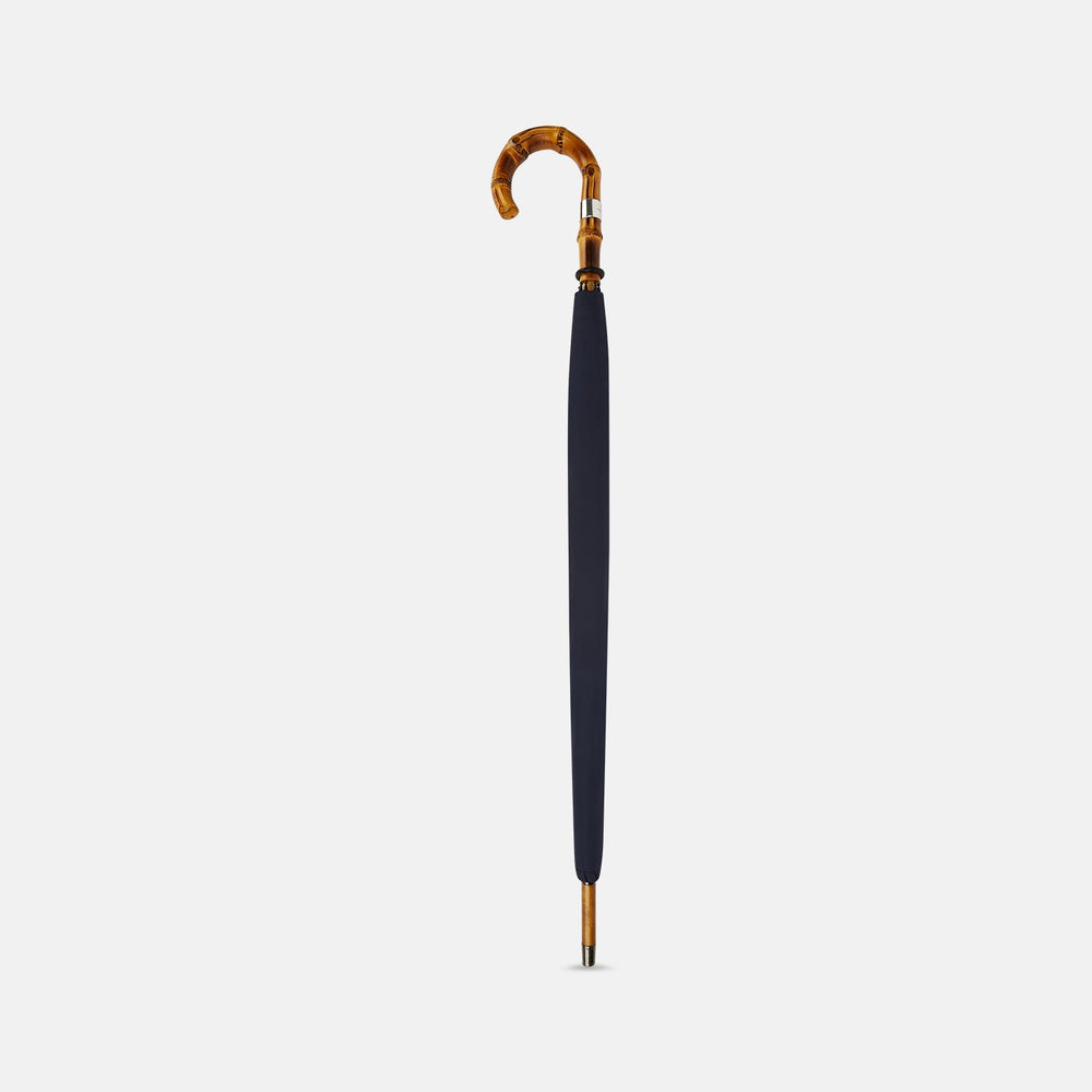 The Turnbull & Asser Navy Umbrella with Whangee Crook Handle is fully open, displaying its dark blue canopy and wooden curved handle against a plain white background.