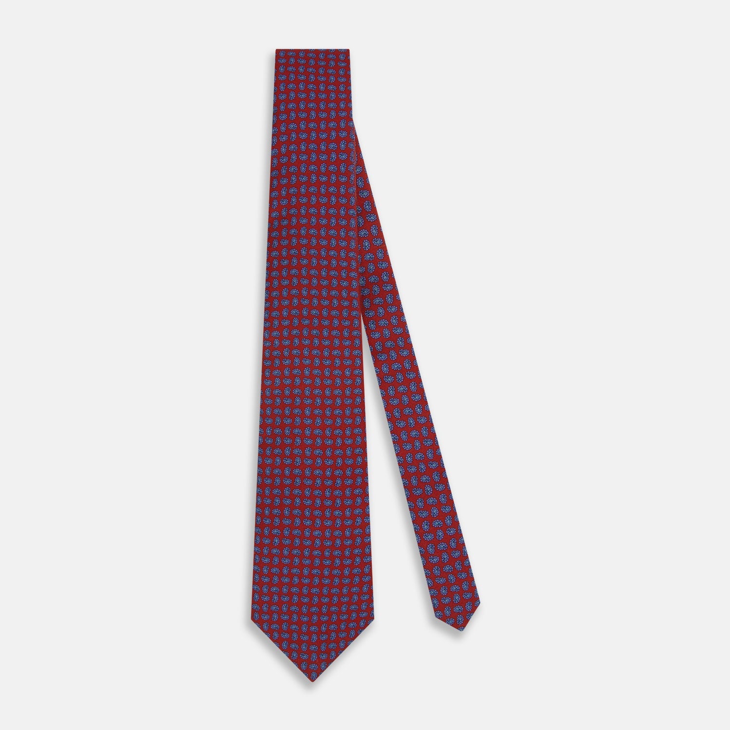 View 2 of product The Turnbull & Asser Red and Purple Miniature Paisley Silk Tie is neatly rolled with the pointed end facing forward.