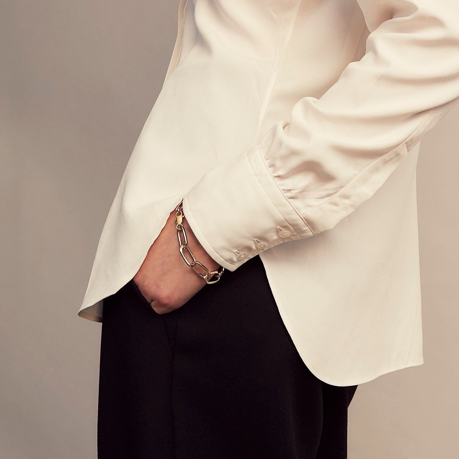 View 9 of product The Cream Silk Tailored Bianca Shirt by Turnbull & Asser features long sleeves, a pointed collar, and curved hem in soft-touch peace silk with a tailored fit. Shown laid flat on a white background.
