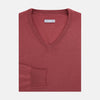 View 4 of product The Turnbull & Asser Antique Pink Merino V-Neck Jumper features ribbed cuffs, hem, and neckline in a soft antique pink, shown on a plain white background. Part of our knitwear collection.