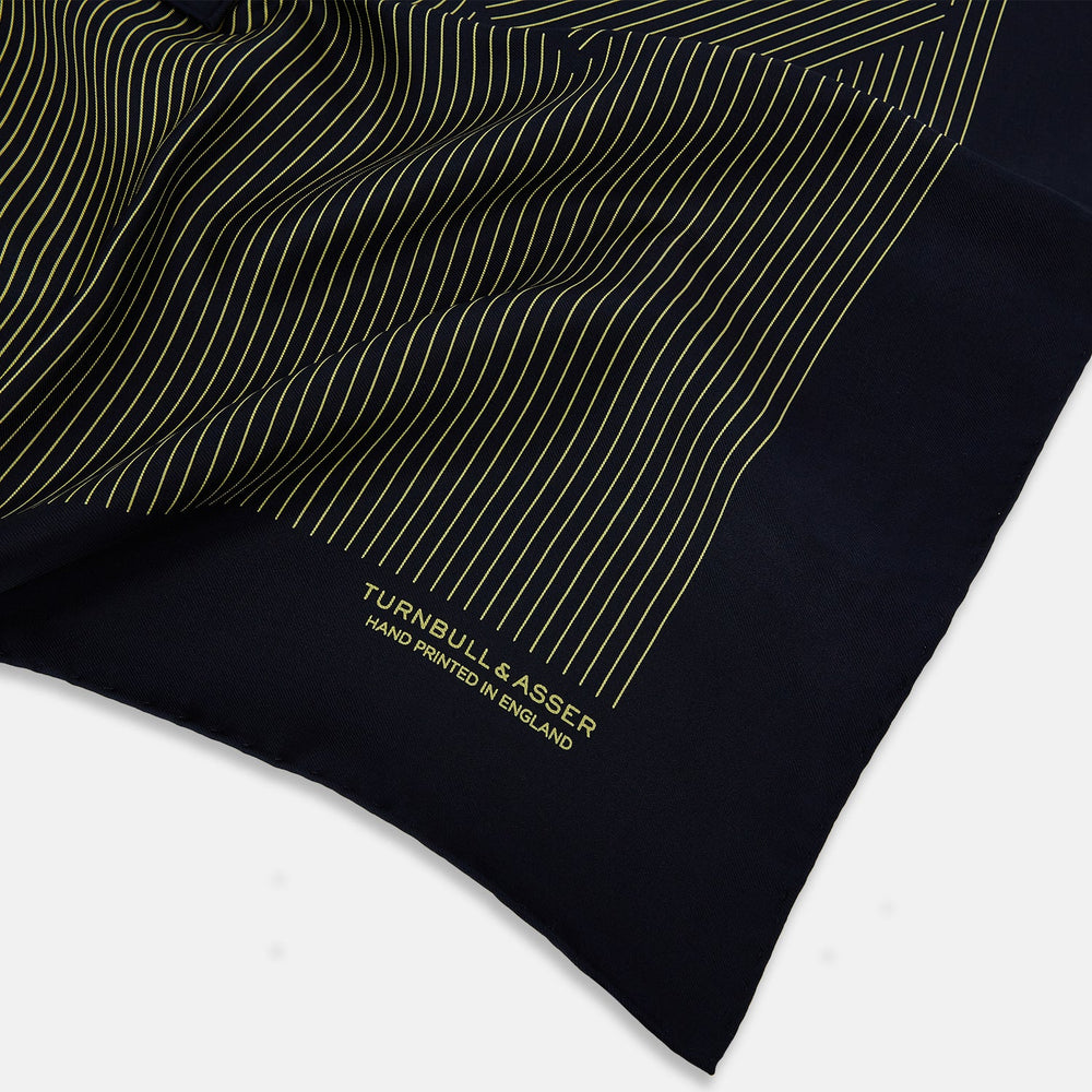 The Turnbull & Asser Navy and Gold Stripe Silk Pocket Square features light yellow vertical stripes, a folded corner, and "TURNBULL & ASSER HAND PRINTED IN ENGLAND" in gold at the bottom right.