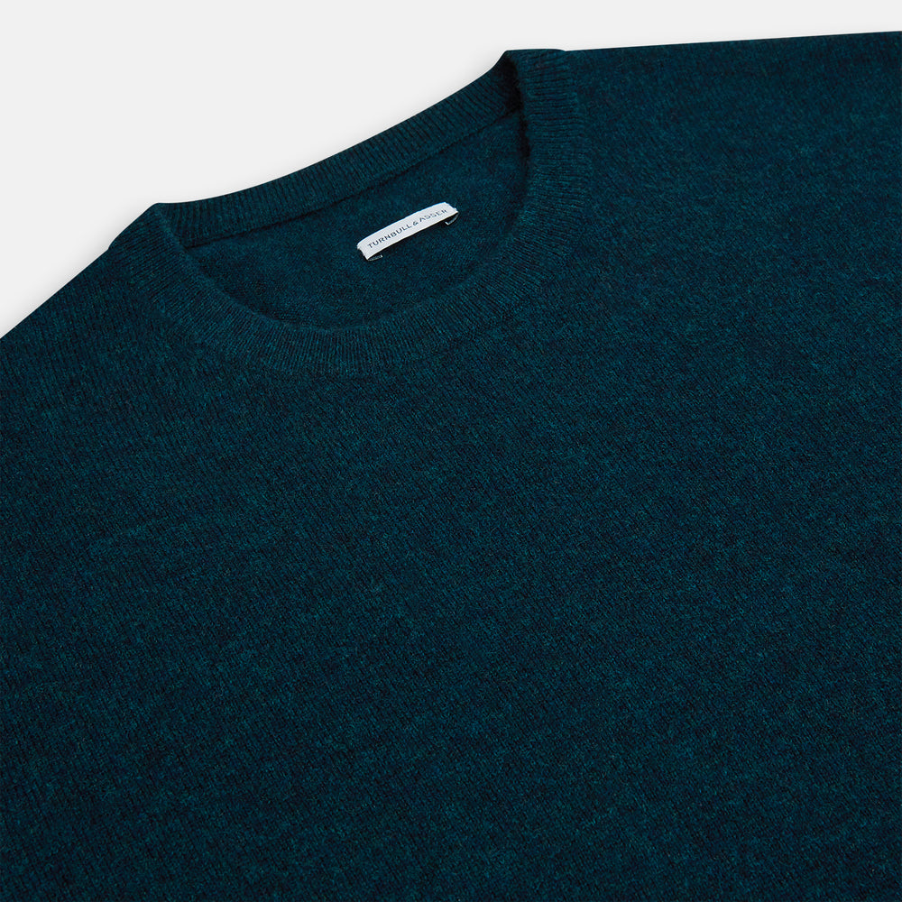 The Turnbull & Asser Dark Green Melange Cashmere Round Neck Jumper features long sleeves with ribbed cuffs and a ribbed hem, shown against a plain white background.
