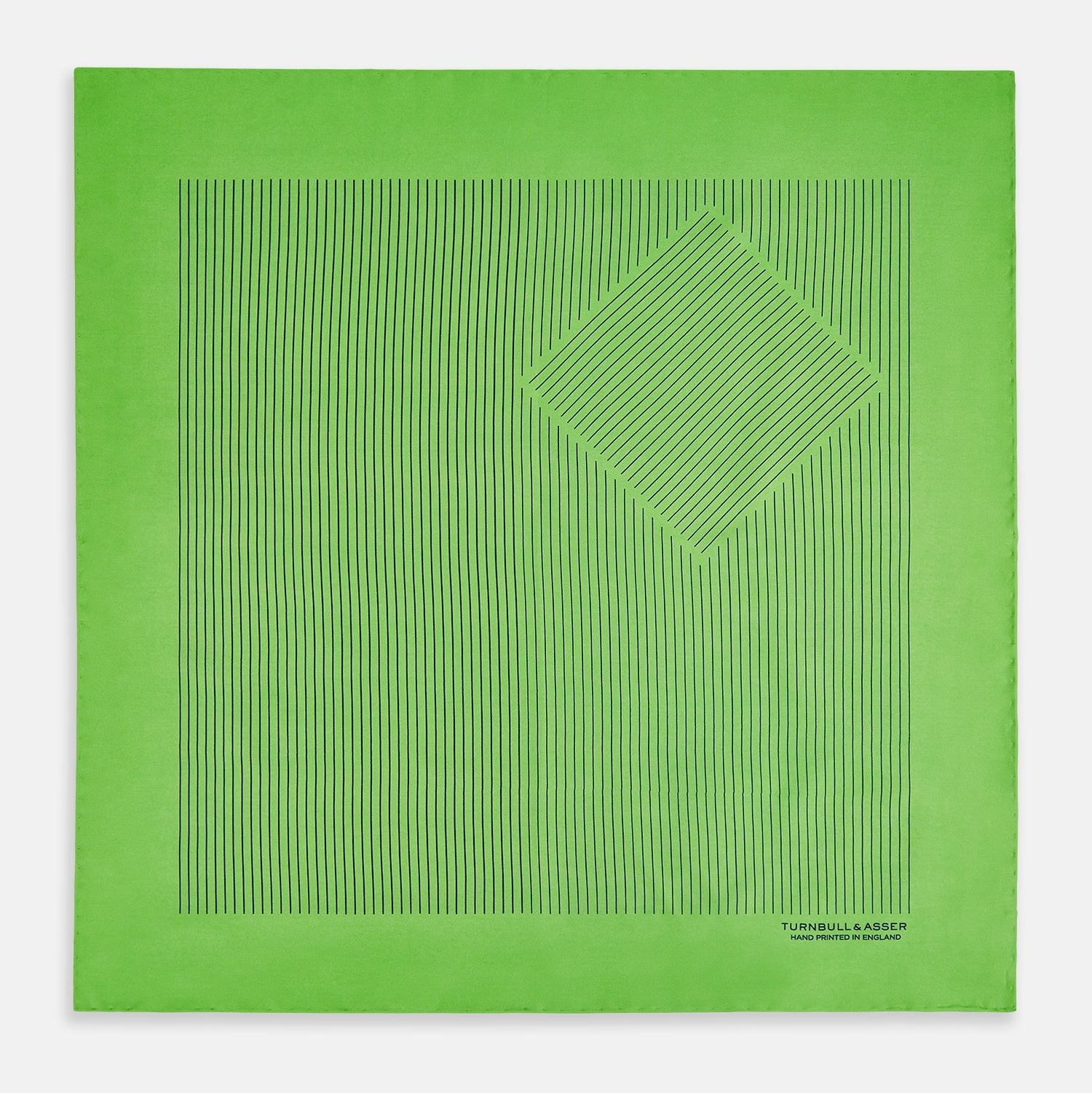 View 3 of product The Fern Green Stripe Silk Pocket Square by Turnbull & Asser features thin black vertical stripes, celebrates British heritage, and is inscribed “TURNBULL & ASSER HAND PRINTED IN ENGLAND” in one corner; one corner is folded inward.
