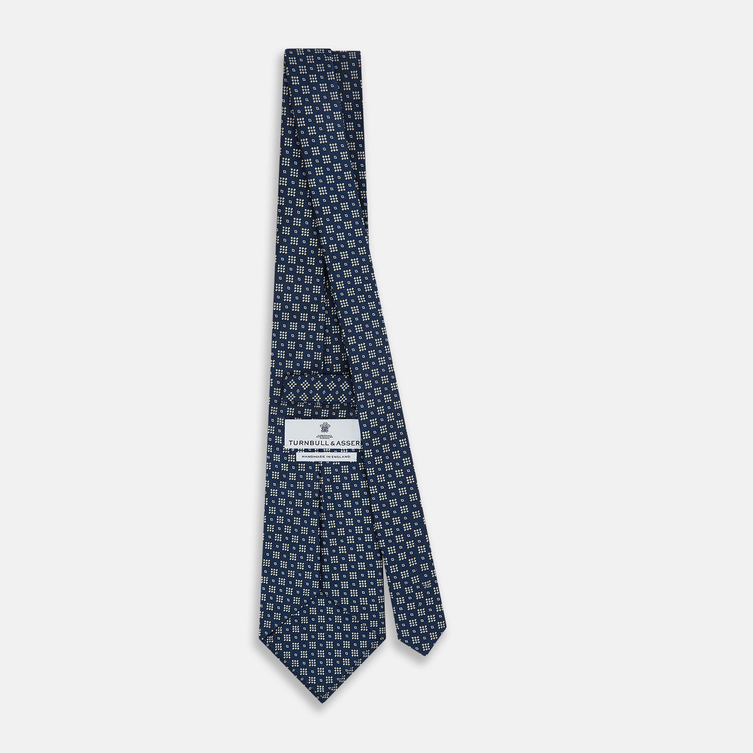 View 4 of product The Turnbull & Asser Navy Diamond Silk Tie features a diamond pattern of small white and yellow squares, embodying British craftsmanship, shown on a plain white background.