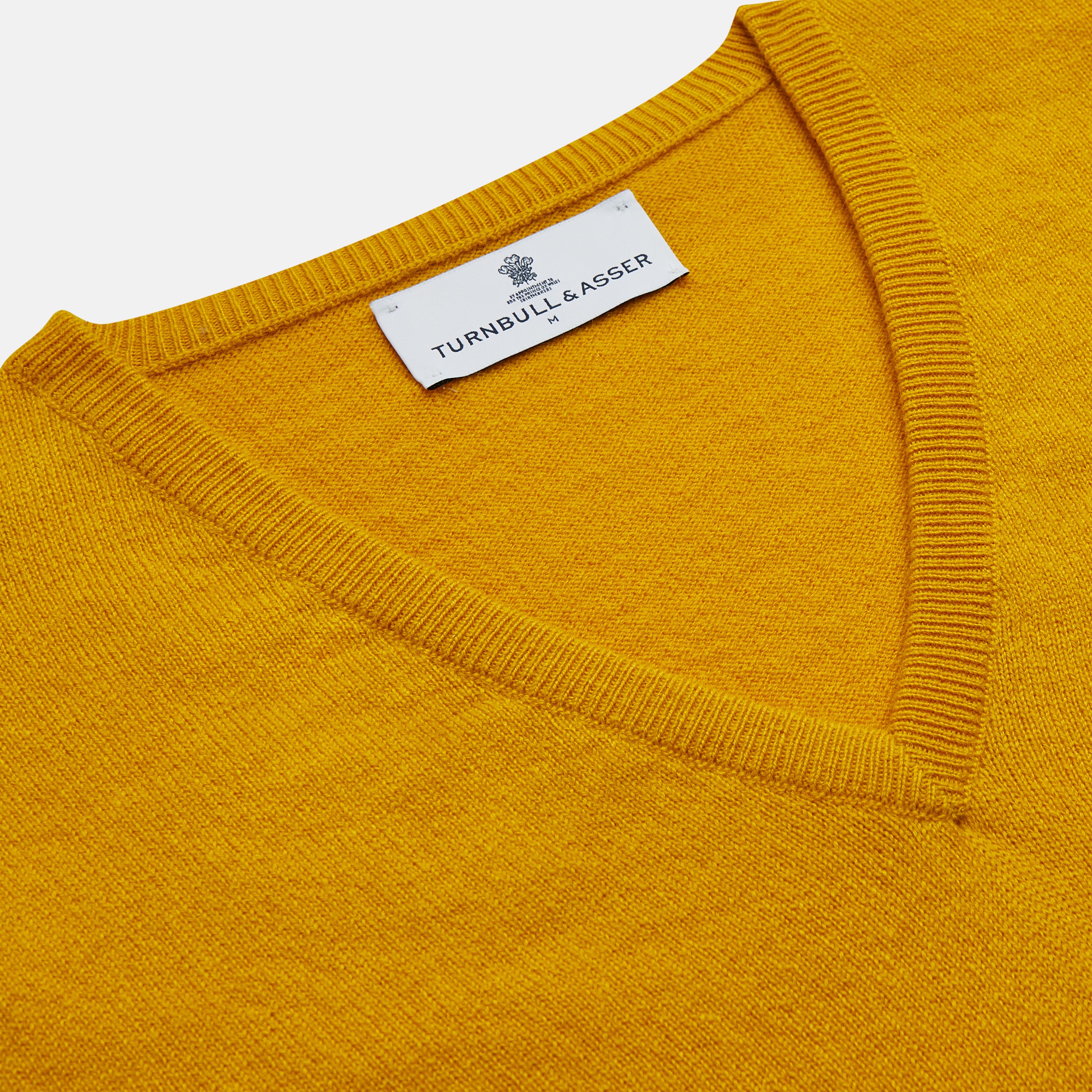 View 2 of product The Gold Ifor Cashmere Slipover by Turnbull & Asser is a sleeveless, V-neck knit in bright mustard yellow, made in Scotland and shown laid flat against a white background.