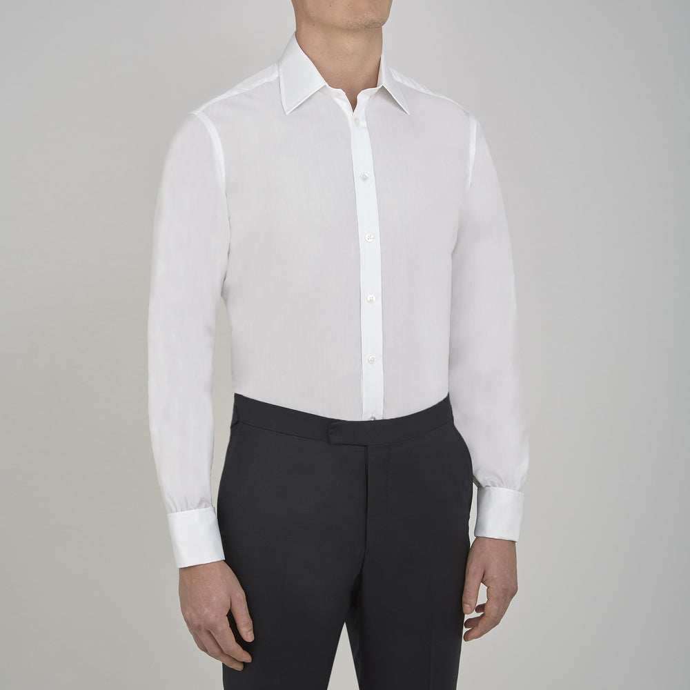 A Turnbull & Asser Two-Fold 200 White Cotton Shirt with T&A collar and double cuffs, neatly folded to show the label inside the collar, is displayed on a light blue background.