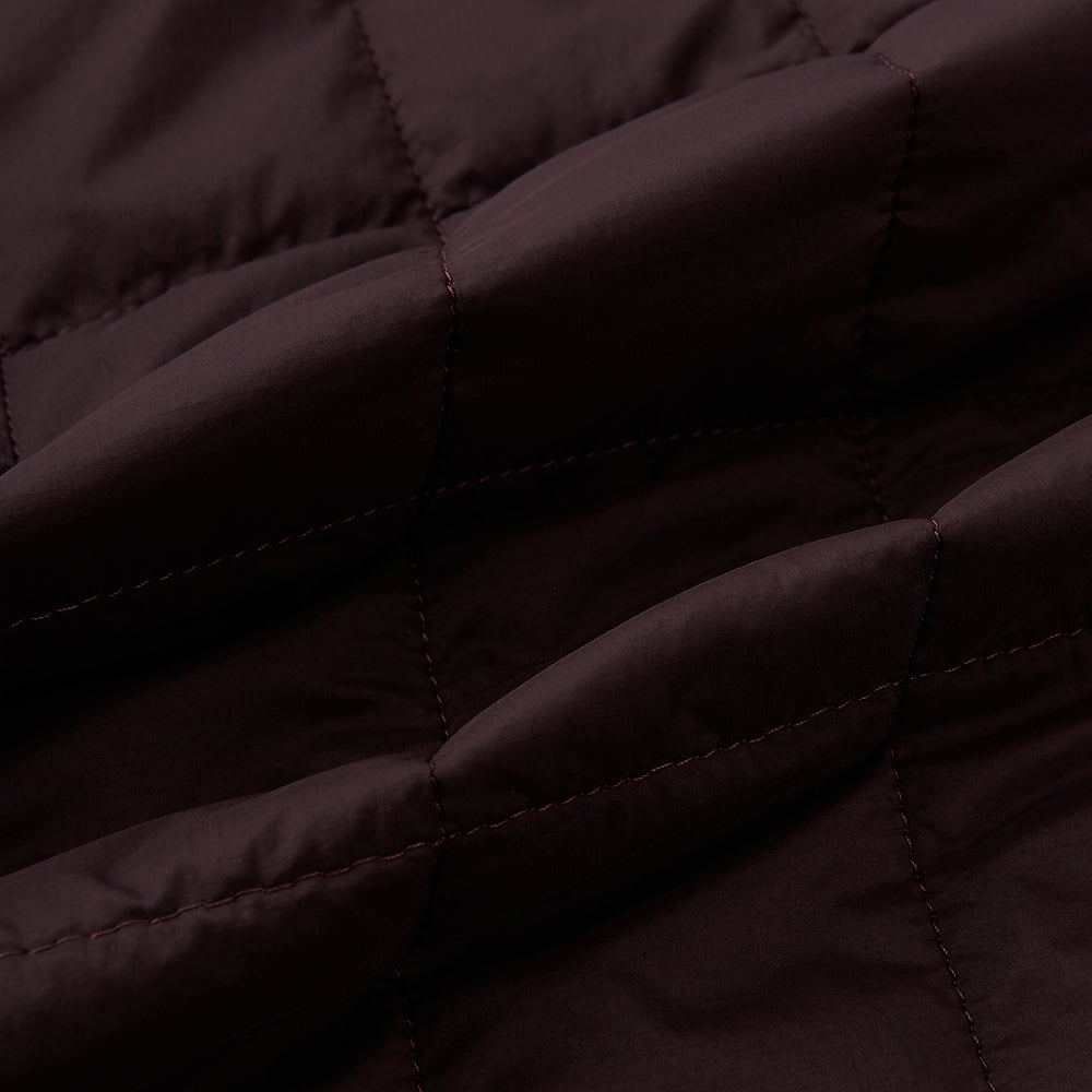 The Battersea Burgundy Quilted Jacket by Turnbull & Asser is a men's elegant outerwear featuring a front zipper, zippered side pockets, chest pocket, pointed collar, and buttoned cuffs, shown on a plain white background.