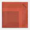 View 3 of product The Orange Dot Silk Pocket Square by Turnbull & Asser is handmade in England from silk, featuring small black polka dots and a solid orange border with a folded corner.
