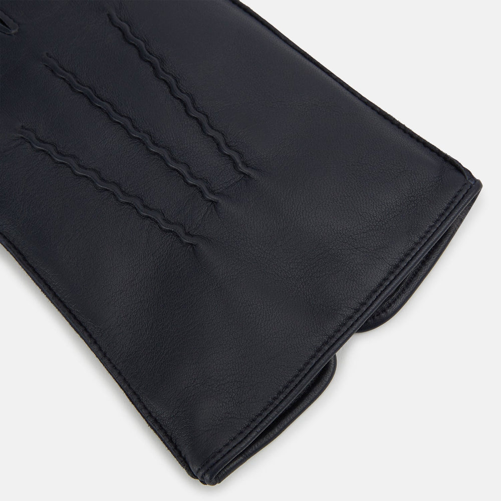 A pair of Turnbull & Asser Navy/Grey Fur-Lined Hairsheep Leather Touchscreen Gloves is displayed on a light background, with one glove showing the palm and the other the back, both featuring simple stitched details and a wrist button closure.