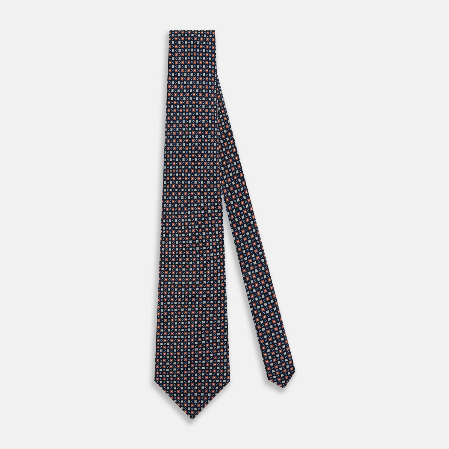 View 2 of product The Turnbull & Asser Navy and Orange Geometric Motif Silk Tie features a dark blue base with small orange, white, and light blue geometric patterns—a refined statement of British craftsmanship.