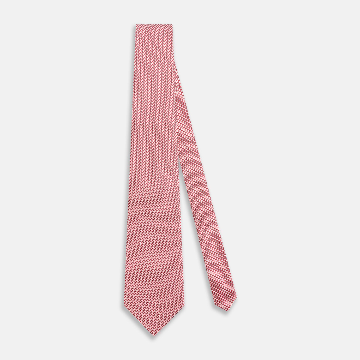 View 2 of product The Turnbull & Asser Pink and White Houndstooth Silk Tie features a small pattern and is displayed rolled up on a plain white background, making it perfect for pairing with any office shirt.