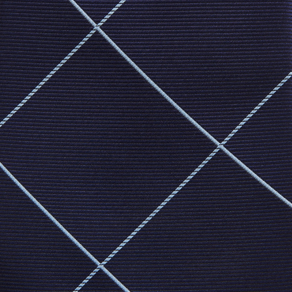 The Turnbull & Asser WINDOW PANE NAVY RIVER TIE features a navy blue base with a subtle light blue check pattern, elegantly rolled on a white background—a sophisticated men's accessory for any wardrobe.