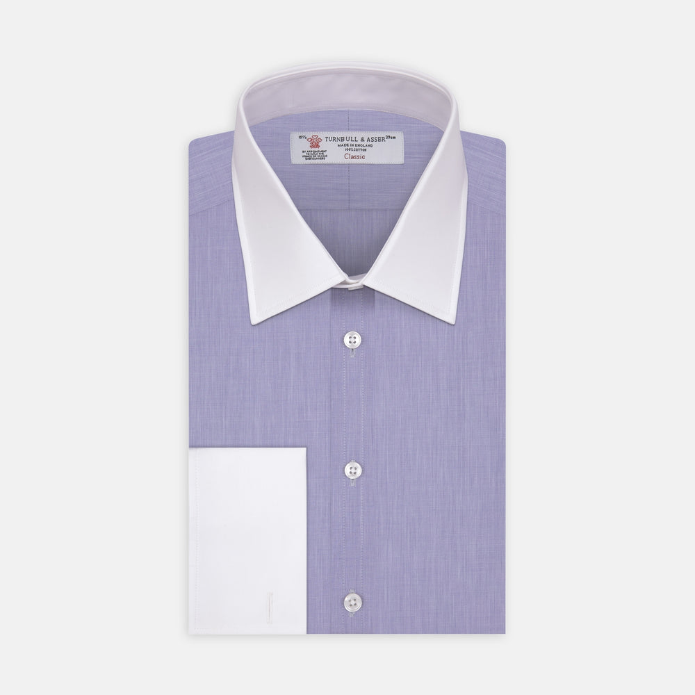 The Wall Street Shirt with White T&A Collar by Turnbull & Asser, as seen on Gordon Gekko, is folded neatly to showcase its light purple color, crisp French cuffs, and iconic contrasting collar against a plain background.