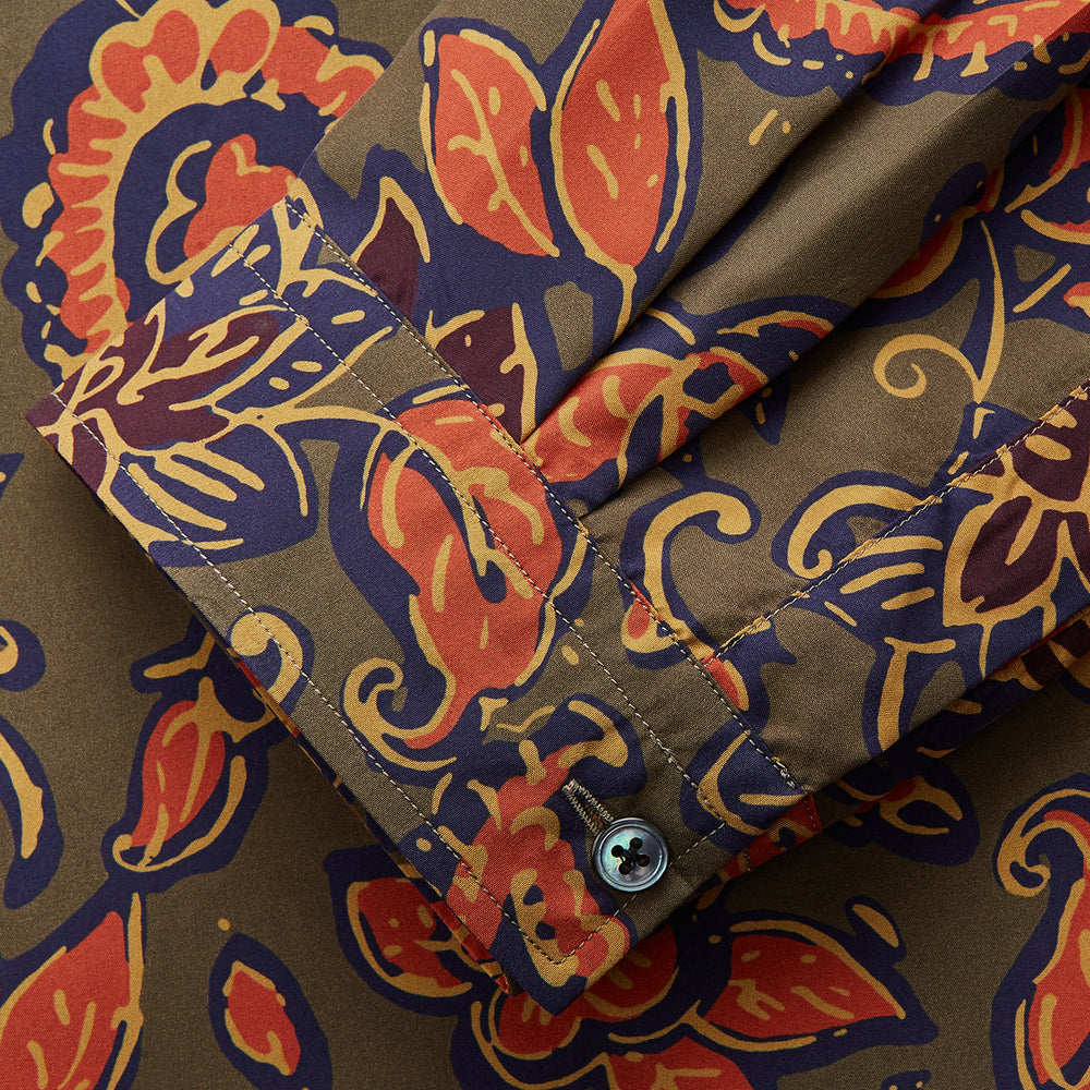 The Turnbull & Asser Khaki Green Floral Silk Holiday Fit Winnington Shirt features a bold floral print with orange, yellow, and purple on an olive background, plus a spread collar and chest pocket for versatile style.