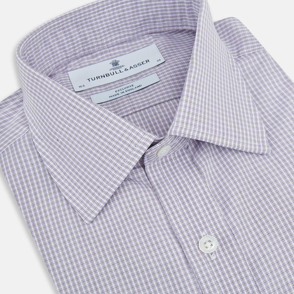 The Turnbull & Asser Purple Micro Check Mayfair Shirt features long sleeves, button-up front, pointed collar, and buttoned cuffs in a subtle lilac and white check, exemplifying British craftsmanship and displayed on a white background.
