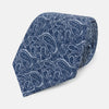 View 1 of product The Turnbull & Asser Pale Blue Paisley Printed Silk Tie is displayed rolled up on a white background, showcasing its intricate paisley pattern in varied blue tones.