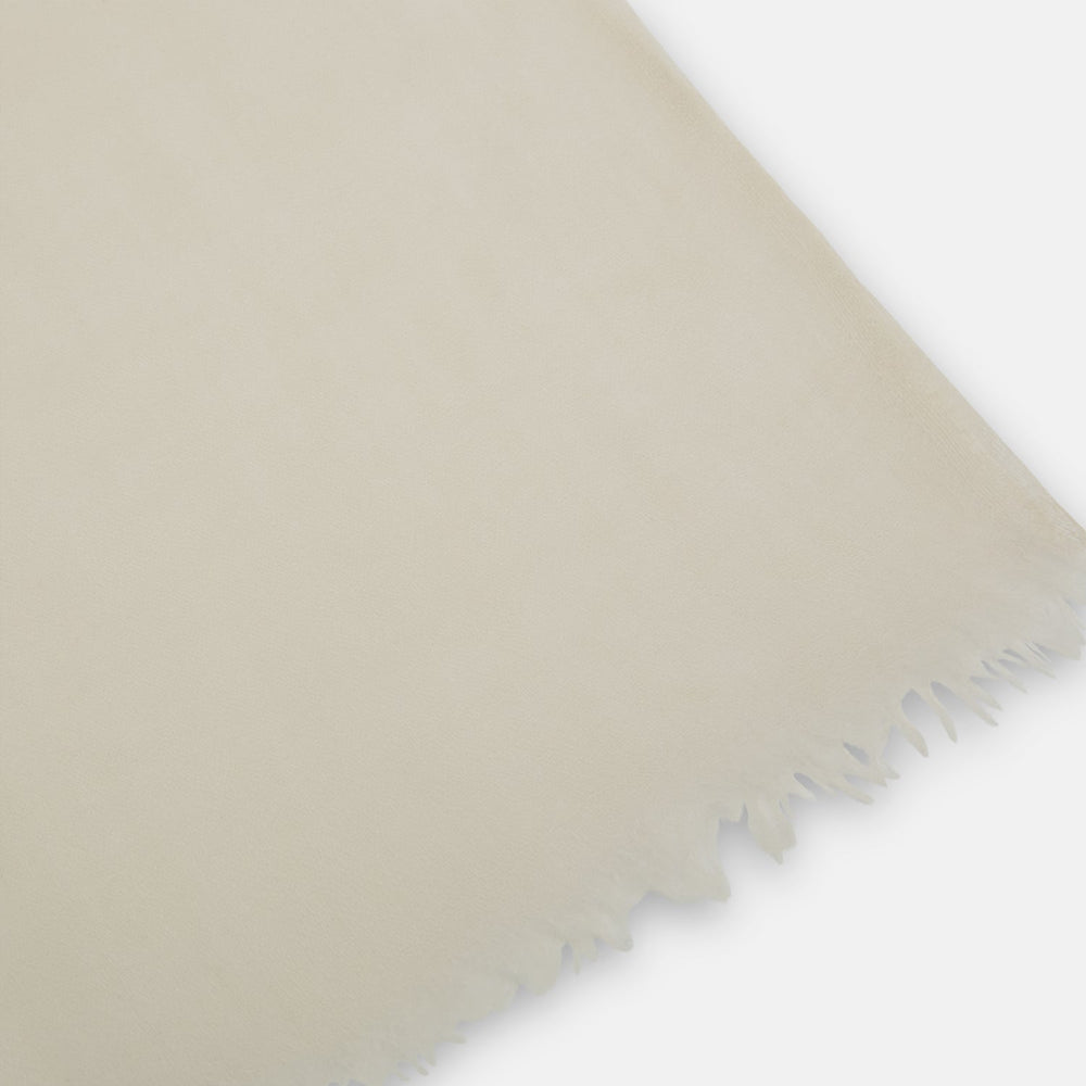 The Turnbull & Asser Rose Cashmere Scarf, in light beige and semi-sheer, is elegantly folded on a white background—an exquisite luxury accessory.