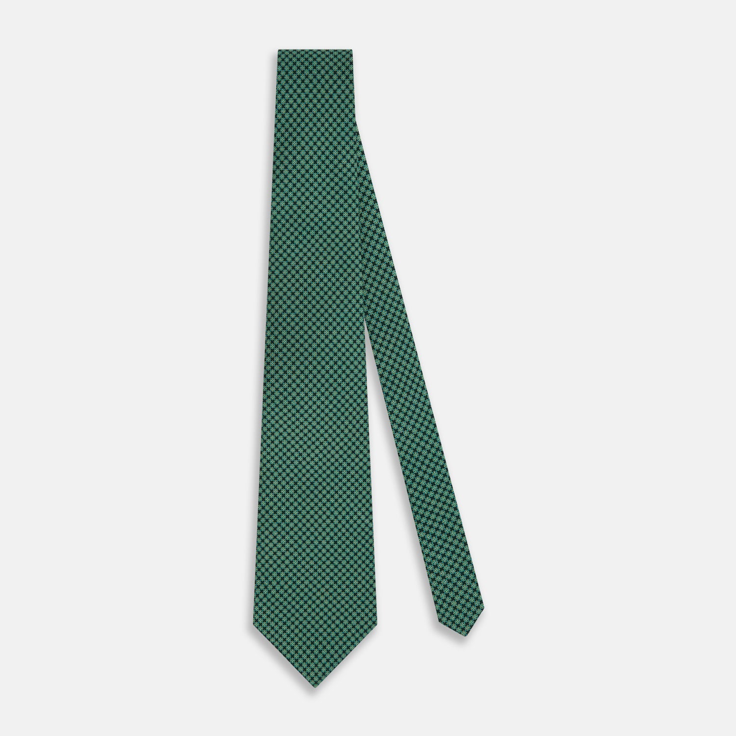View 2 of product The Forest Green Geometric Floral Printed Silk Tie by Turnbull & Asser is shown rolled up on a white background, its English silk material featuring an elegant green and turquoise pattern.