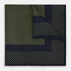 View 1 of product The Turnbull & Asser Navy and Yellow Dot Silk Pocket Square features a navy base with yellow dots, a solid navy border, and a folded corner showing the patterned underside for an elegant accent.