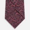 View 3 of product The Turnbull & Asser Orange Paisley Silk Tie, crafted from fine English silk, features an elegant paisley pattern and is stylishly rolled up on a plain white background.