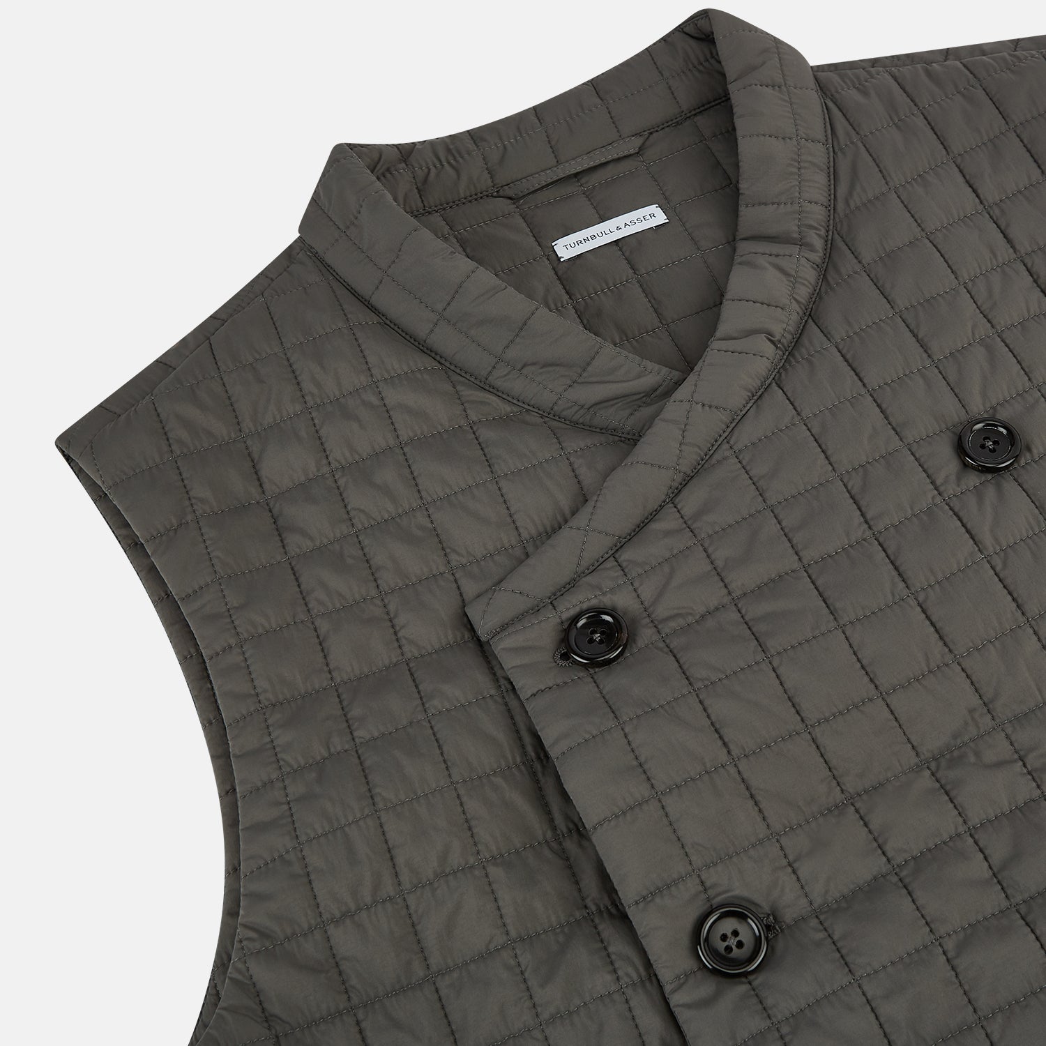 Image 2 of product The Turnbull & Asser Shadow Grey Double-Breasted Quilted Gilet features a sleeveless design, asymmetrical collar, side zip pockets, slanted chest pocket, grid pattern, and modern black buttons—perfect for layered dressing.