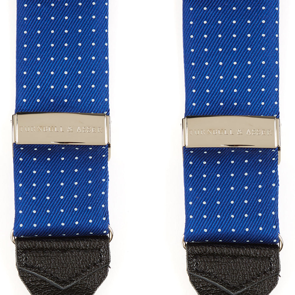 Turnbull & Asser Royal Blue Small Spot Adjustable Silk Braces, detailed with black leather ends and silver clips, are perfect for refined style. Shown laid flat on a plain white background.