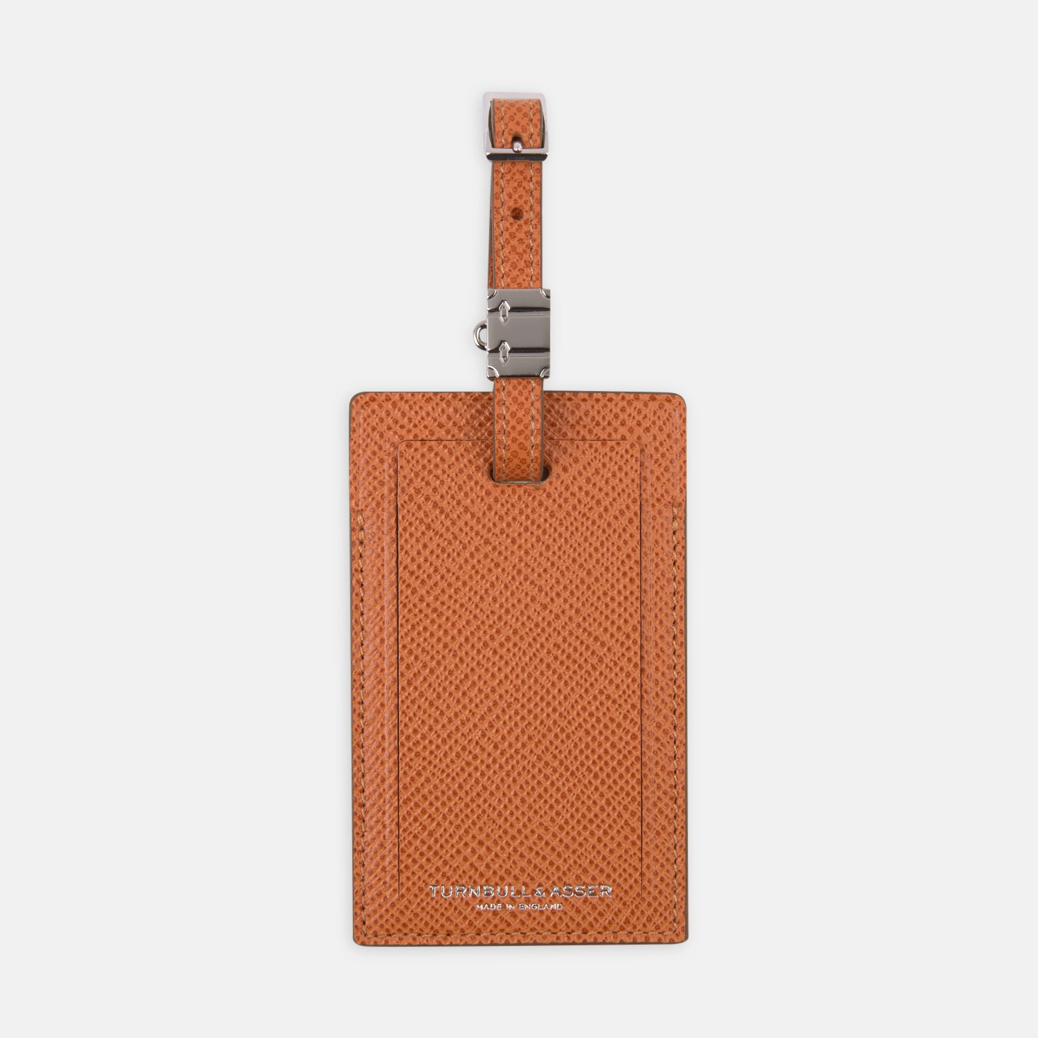 View 1 of product The Brown Leather Luggage Tag by Turnbull & Asser features textured brown leather, a silver buckle strap, and the Turnbull & Asser name embossed in silver at the bottom.