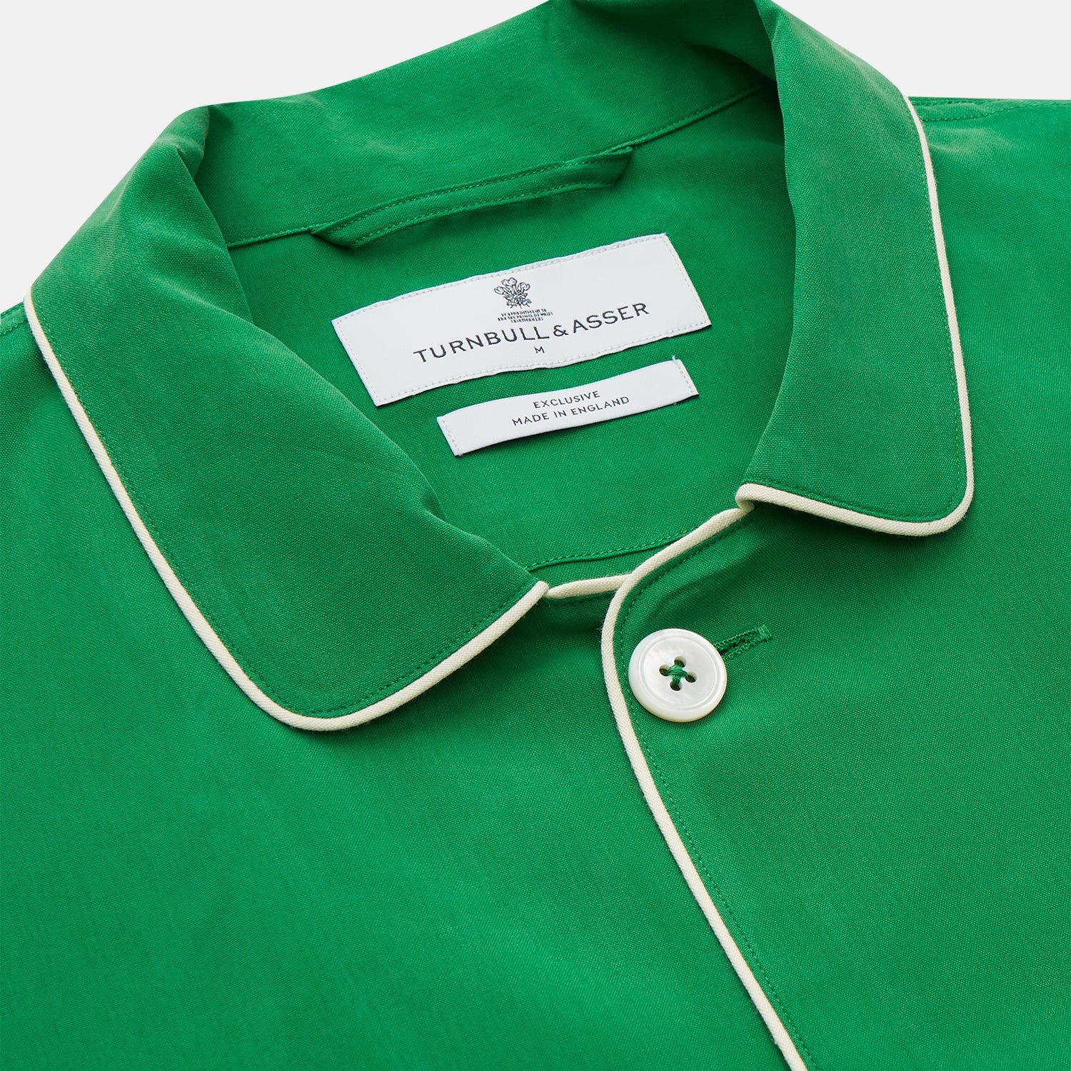 View 4 of product The Turnbull & Asser Green Silk Hyde Pyjamas Set features a long-sleeve button-up top with three pockets and modern fit elastic waistband pants in silk blend, both shown laid flat on a white background.