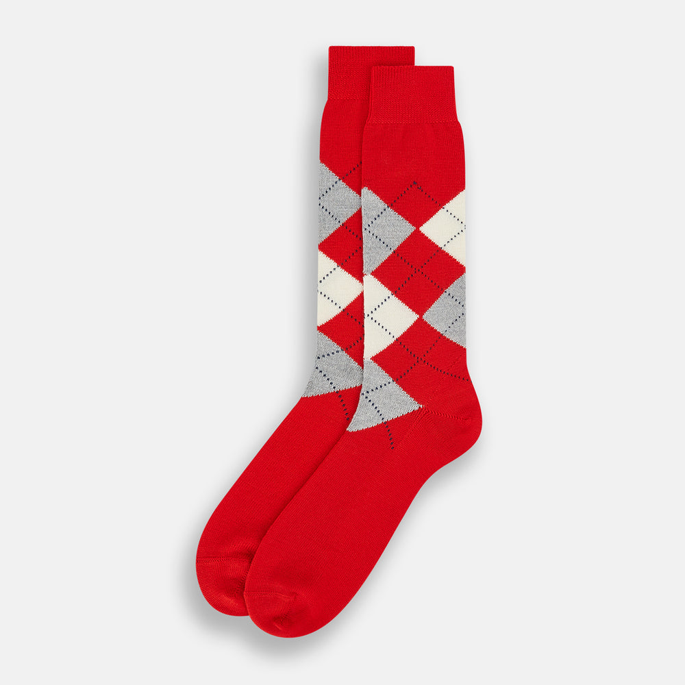 Mid-length orange wool socks by Turnbull & Asser, featuring a classic check pattern in orange, beige, and gray, reminiscent of timeless wool socks, displayed on a plain light background.