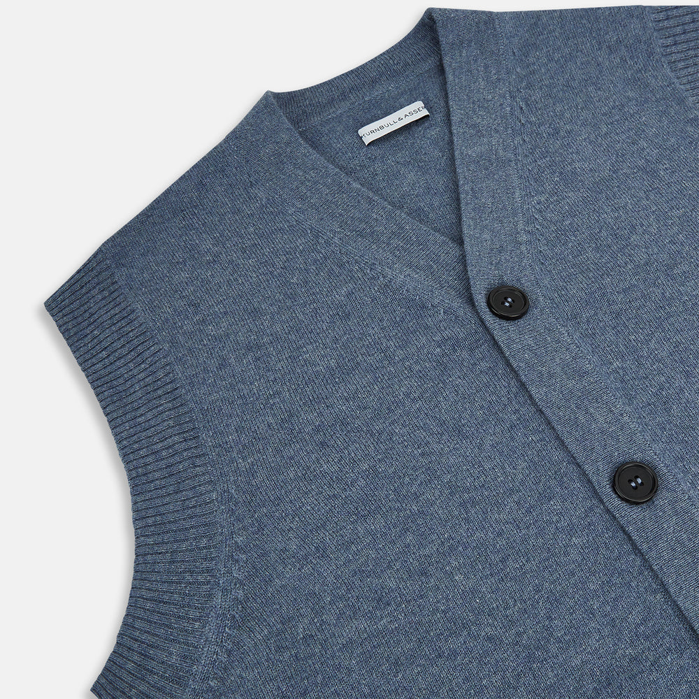 The Blue Melange Cashmere Sleeveless Cardigan by Turnbull & Asser features a V-neck, button-up front, ribbed collar and hem, and two front pockets, shown on a plain white background.