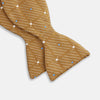 View 3 of product The Thistle Petersham Double End Bow Tie by Turnbull & Asser features a golden brown hue with a subtle diagonal stripe and blue and white square accents—an elegant accessory, pictured on a plain white background.