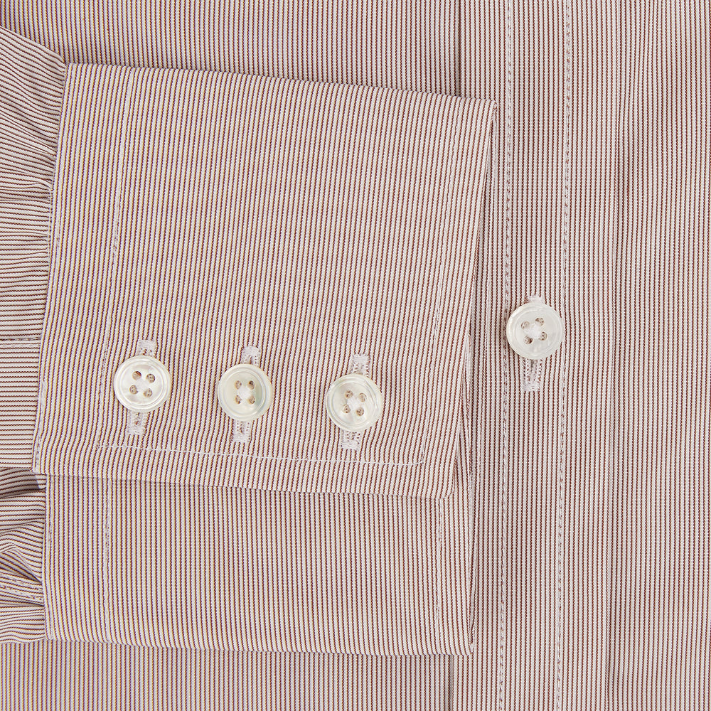 The Turnbull & Asser Burgundy Hairline Stripe Mayfair Shirt features long sleeves, a pointed collar, white buttons, and a classic Mayfair fit—perfect for formal occasions—presented against a plain white background.