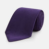 View 1 of product The HOUNDSTOOTH NAVY PLUM TIE by Turnbull & Asser, featuring a textured pattern, is showcased rolled up against a plain white background—an essential accessory.