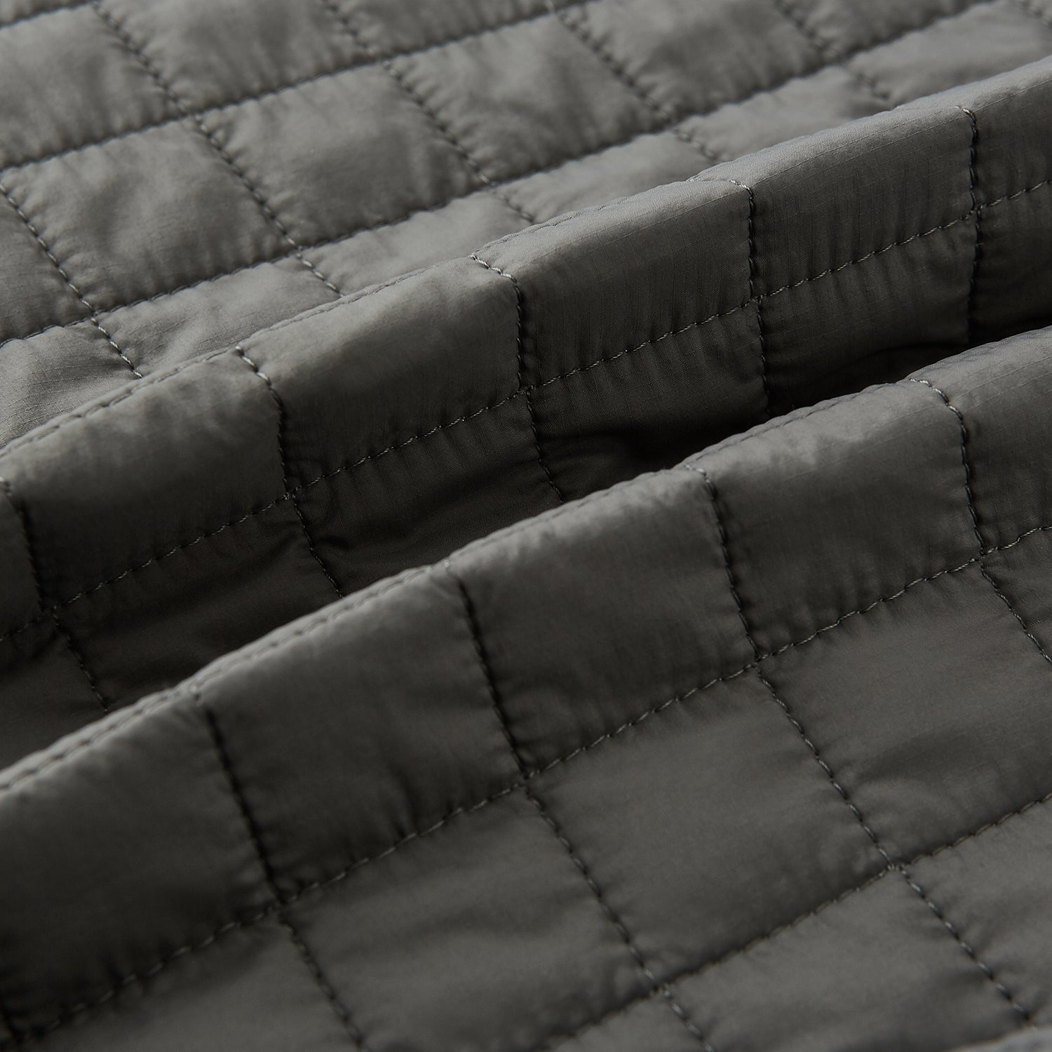 Image 4 of product The Turnbull & Asser Shadow Grey Double-Breasted Quilted Gilet features a sleeveless design, asymmetrical collar, side zip pockets, slanted chest pocket, grid pattern, and modern black buttons—perfect for layered dressing.