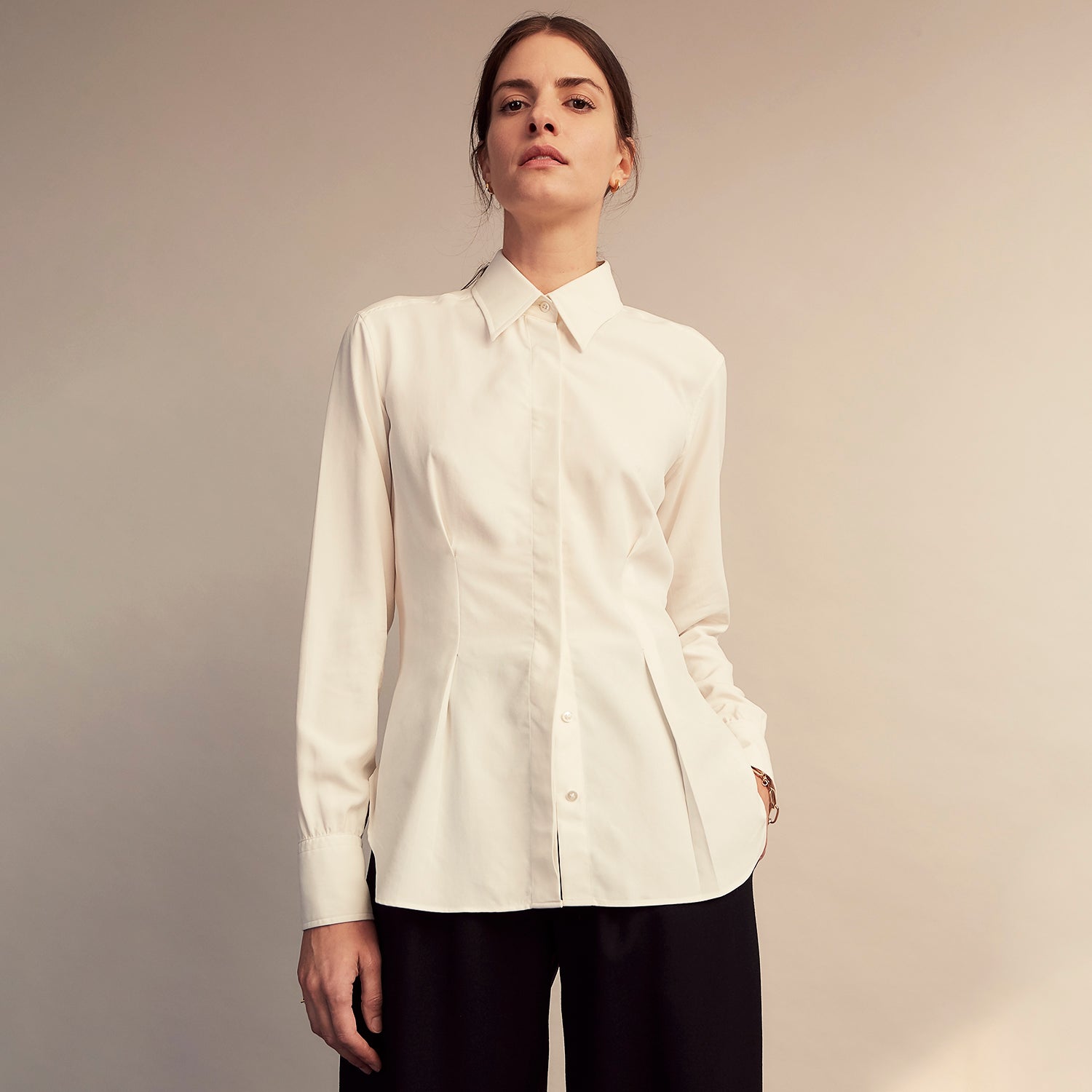 View 5 of product The Cream Silk Tailored Bianca Shirt by Turnbull & Asser features long sleeves, a pointed collar, and curved hem in soft-touch peace silk with a tailored fit. Shown laid flat on a white background.