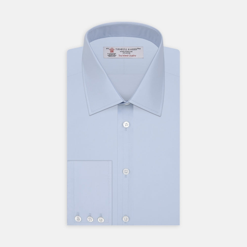 A circular swatch of Turnbull & Asser Light Blue Sea Island Quality Cotton Fabric, subtly textured and bordered by thin gray and white rings, displayed on a plain white background.