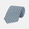 View 1 of product The Great Gatsby Silk Tie by Turnbull & Asser, as seen on Jay Gatsby—a light blue silk tie with red, yellow, and navy geometric floral motifs, ideal for classic 1920s-inspired shirts.
