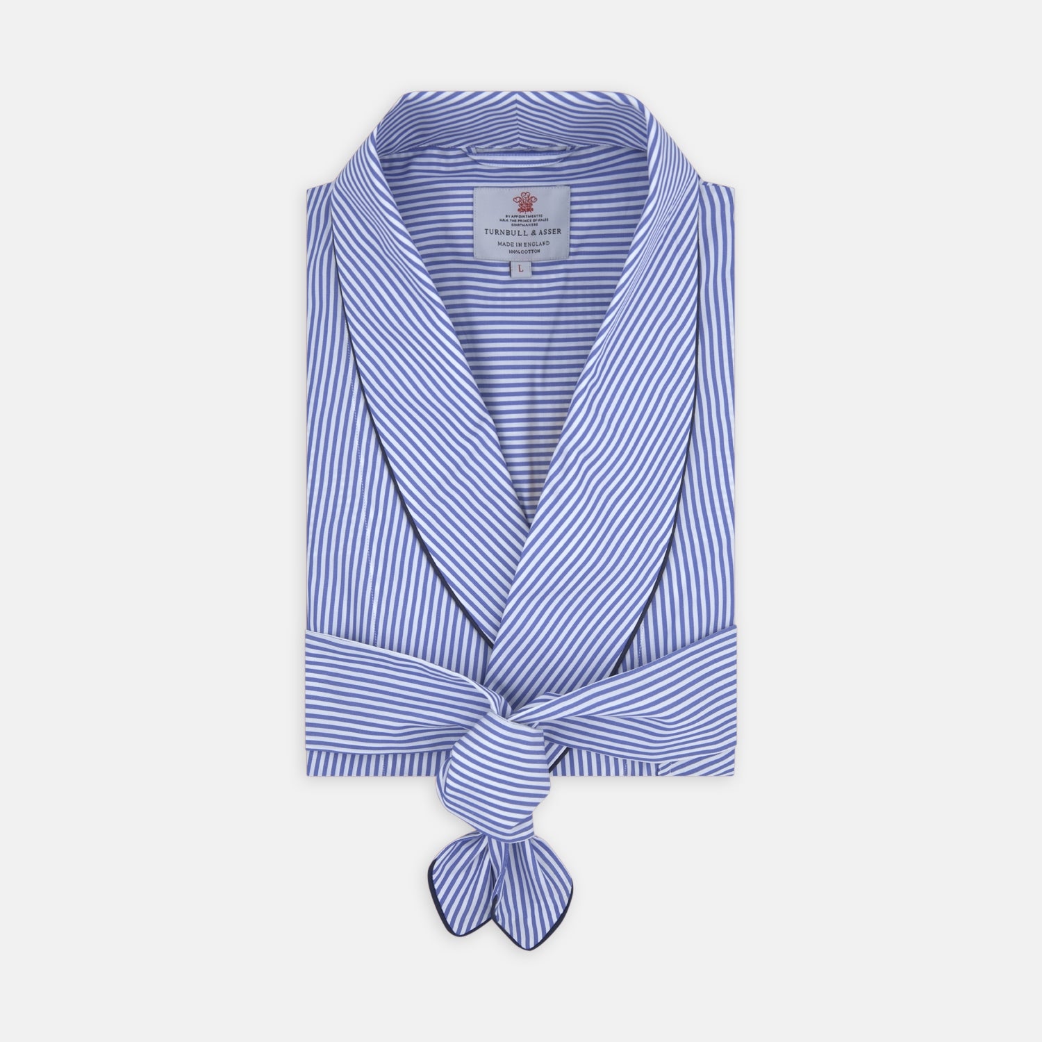View 1 of product The Turnbull & Asser Blue Bengal Stripe Piped Cotton Gown, featuring a shawl collar and belt, is elegantly folded and displayed on a white background.