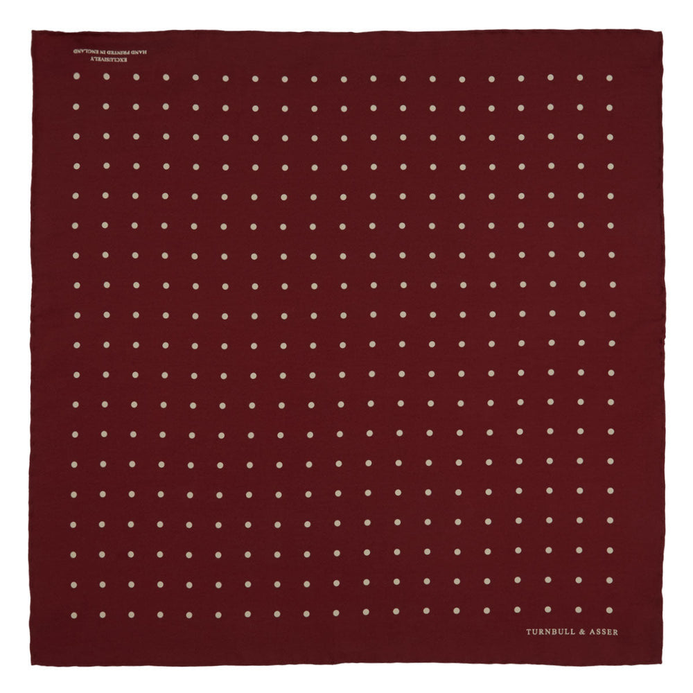 Add a touch of elegance with the Turnbull & Asser Burgundy Spot Silk Pocket Square, featuring white dots, a printed corner logo, and folded edging—a classic men’s accessory for any occasion.